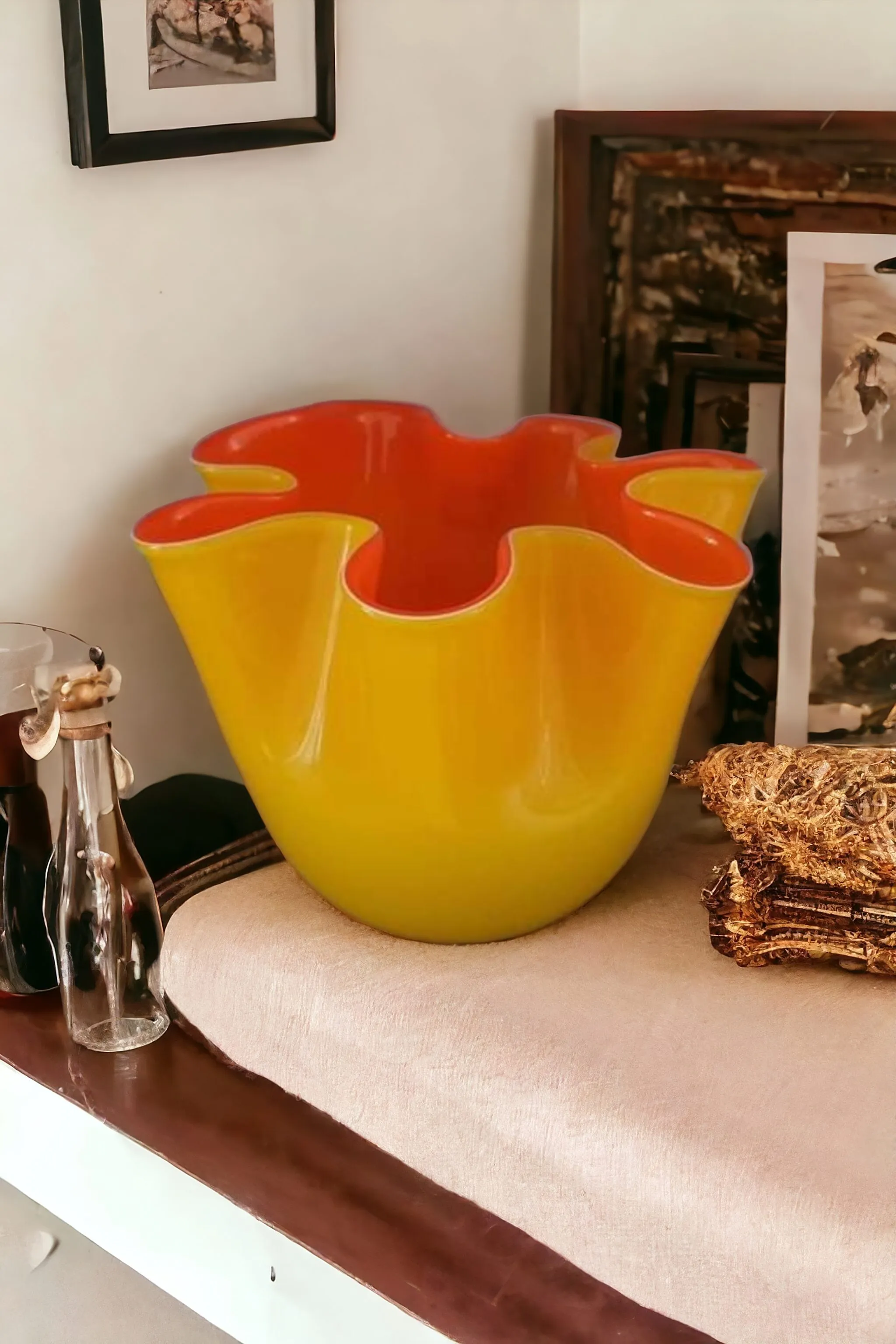 Le Vase Mouchoir Leonardo est un élégant exemple de verre artisanal fabriqué à Murano, célèbre pour sa forme caractéristique en Mouchoir. Ce vase tire son nom de son design distinctif qui rappelle un mouchoir de tissu drapé, avec les pointes froncées et un effet doux qui capte la lumière de manière unique. Le travail du verre de Murano est depuis toujours un signe de qualité et de tradition, et ce vase ne fait pas exception, reflétant la maîtrise des verriers muranais. Caractéristiques principales : Design Mouchoir : La forme du vase est caractérisée par des courbes douces et des plis qui rappellent un mouchoir de tissu, un design qui donne au vase un aspect dynamique et fluide, comme s'il avait été sculpté par la lumière elle-même. Couleurs vives et translucides : Fabriqué en verre soufflé, le vase peut présenter une variété de couleurs, souvent vives ou dégradées, comme le bleu, le rouge, le vert ou le blanc, qui mettent en valeur la brillance et la transparence caractéristiques du verre de Murano. Technique de fabrication : Le vase est soufflé à la main, utilisant la technique traditionnelle du verre de Murano, ce qui permet d'obtenir des formes et des nuances uniques, faisant de chaque vase une pièce vraiment exclusive. Pourquoi le choisir : Le Vase Mouchoir Leonardo est un choix idéal pour ceux qui recherchent une œuvre d'art décorative alliant esthétique et tradition. Parfait pour ceux qui apprécient la beauté du verre de Murano et veulent ajouter une touche d'élégance à n'importe quel environnement, le vase n'est pas seulement un objet fonctionnel, mais une véritable œuvre d'art qui enrichit l'atmosphère de chaque pièce. Avec son design fluide et sa qualité impeccable, c'est un accessoire de décoration qui ne passera pas inaperçu.