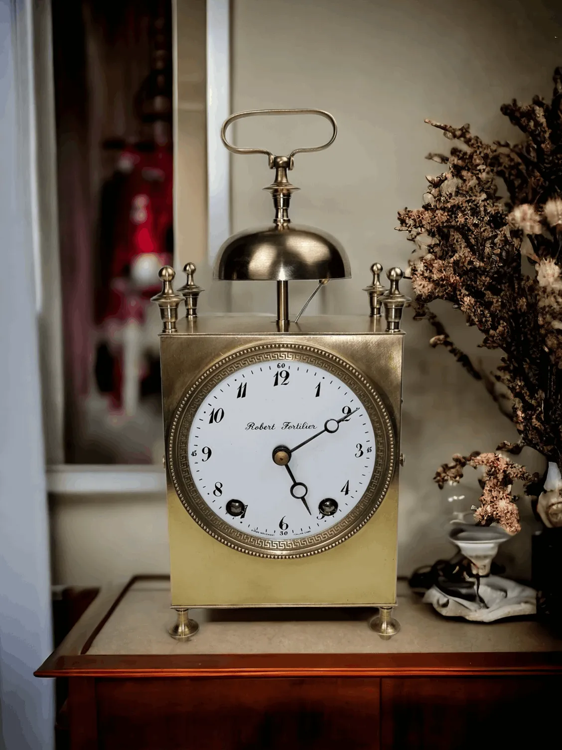 L'Horloge de voyage ancienne Cappuccina avec mouvement suisse et boîtier italien réalisée par Robert Fortilier est un élégant modèle d'horloge de voyage. Ce modèle se distingue par un boîtier robuste mais compact, typique des horloges de voyage de la fin du XIXe et du début du XXe siècle, qui protège le délicat mécanisme à l'intérieur. La Cappuccina est un type d'horloge de voyage qui présente une structure qui s'ouvre comme un capuchon (d'où son nom), et le design inclut souvent une protection pour le cadran, afin d'éviter les dommages pendant le transport. Principales caractéristiques : Mouvement suisse : Le mécanisme est fabriqué avec précision en Suisse, connu pour sa haute qualité et sa fiabilité. Boîtier italien Robert Fortilier : Le boîtier, fabriqué en Italie par Robert Fortilier, se distingue par son artisanat exceptionnel et son design raffiné, utilisant souvent des matériaux de haute qualité tels que l'or ou l'argent, ou du bois précieux. Design compact et protecteur : La structure Cappuccina est conçue pour protéger le mécanisme interne, tout en étant de dimensions relativement réduites, idéales pour le transport. Rareté et valeur pour les collectionneurs : Les horloges de voyage comme celle-ci sont souvent recherchées par les collectionneurs pour leur valeur historique, leur artisanat et la qualité du mouvement suisse. Pourquoi choisir une horloge de voyage Cappuccina ? Ce type d'horloge est parfait pour ceux qui recherchent une pièce rare et fascinante à ajouter à leur collection d'horloges vintage ou anciennes. C'est un exemple parfait de la façon dont la fonctionnalité peut être combinée avec l'élégance et l'artisanat de haute qualité. De plus, une horloge comme celle-ci ajoute une dimension historique à toute collection, représentant l'excellence de l'horlogerie et de l'artisanat italien et suisse.