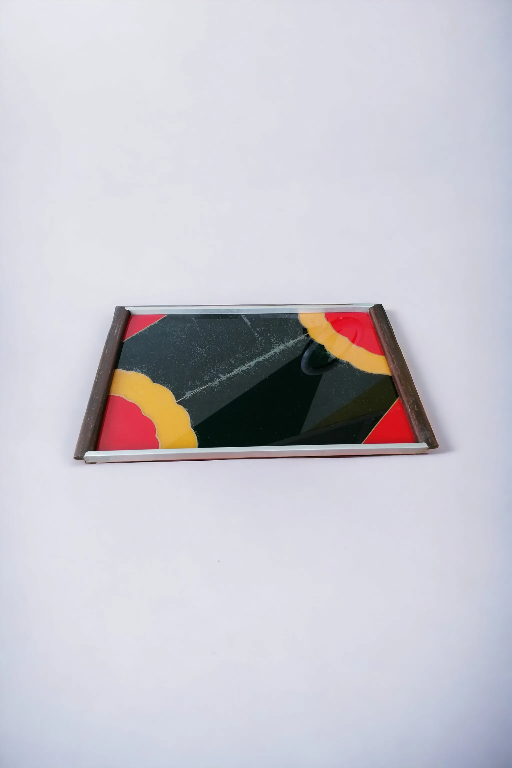 The 1950s designer tray is a true piece of art, symbolizing the elegance and functionality of the era. Made from high-quality materials such as glass, wood, and aluminum, this tray combines flowing shapes and a refined finish, making it a distinctive element in any setting. Measuring 45 cm x 30 cm with a height of 5 cm, it is perfect for serving appetizers, desserts, or as a base for decorations. Its modern Italian design not only catches the eye but is also highly practical, making it ideal for special occasions or daily use. By adding this tray to your decor, you bring a touch of vintage style and class to any table.