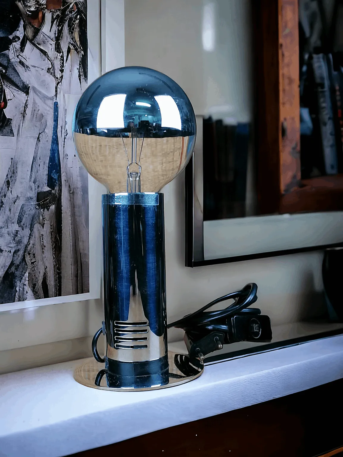 Cette lampe de table TARGETTI SANKEY, au design caractéristique 'space age', incarne l'esthétique futuriste des années 60 et 70. Sa structure en métal chromé, linéaire et brillante, met en valeur un look minimaliste et industriel, tandis que l'ampoule en dôme miroir rappelle des formes spatiales et ajoute un charme unique à l'objet. Ce pièce, en plus d'être une icône du design vintage, crée un éclairage doux et réfléchi qui ajoute de l'atmosphère et du style à n'importe quel environnement. Parfaite pour ceux qui cherchent un objet décoratif alliant histoire du design et fonctionnalité.