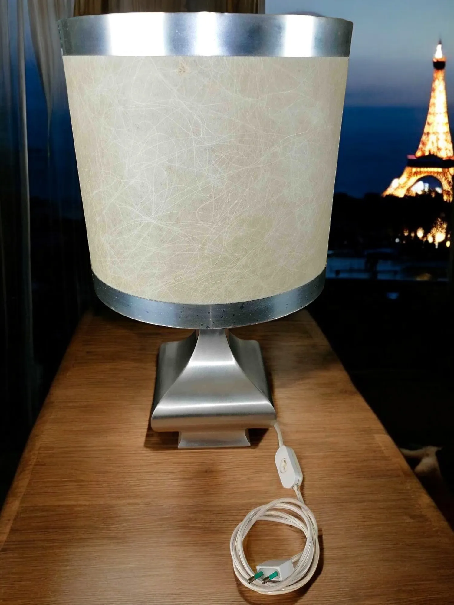 Découvrez l'élégance intemporelle de cette lampe de table satinée, une pièce qui évoque le design iconique de Maria Pergay. Avec une finition satinée qui reflète la lumière délicatement, cette lampe se distingue par sa silhouette raffinée et moderne. L'abat-jour en papier laminé ajoute un contraste unique, diffusant une lumière chaude et accueillante qui enrichit n'importe quel espace. Parfaite pour un coin lecture ou comme élément de design sur un bureau, cette lampe n'est pas seulement fonctionnelle, mais représente également une véritable déclaration de style. Idéale pour les amateurs de design contemporain, cette création est destinée à devenir le point focal de chaque espace.