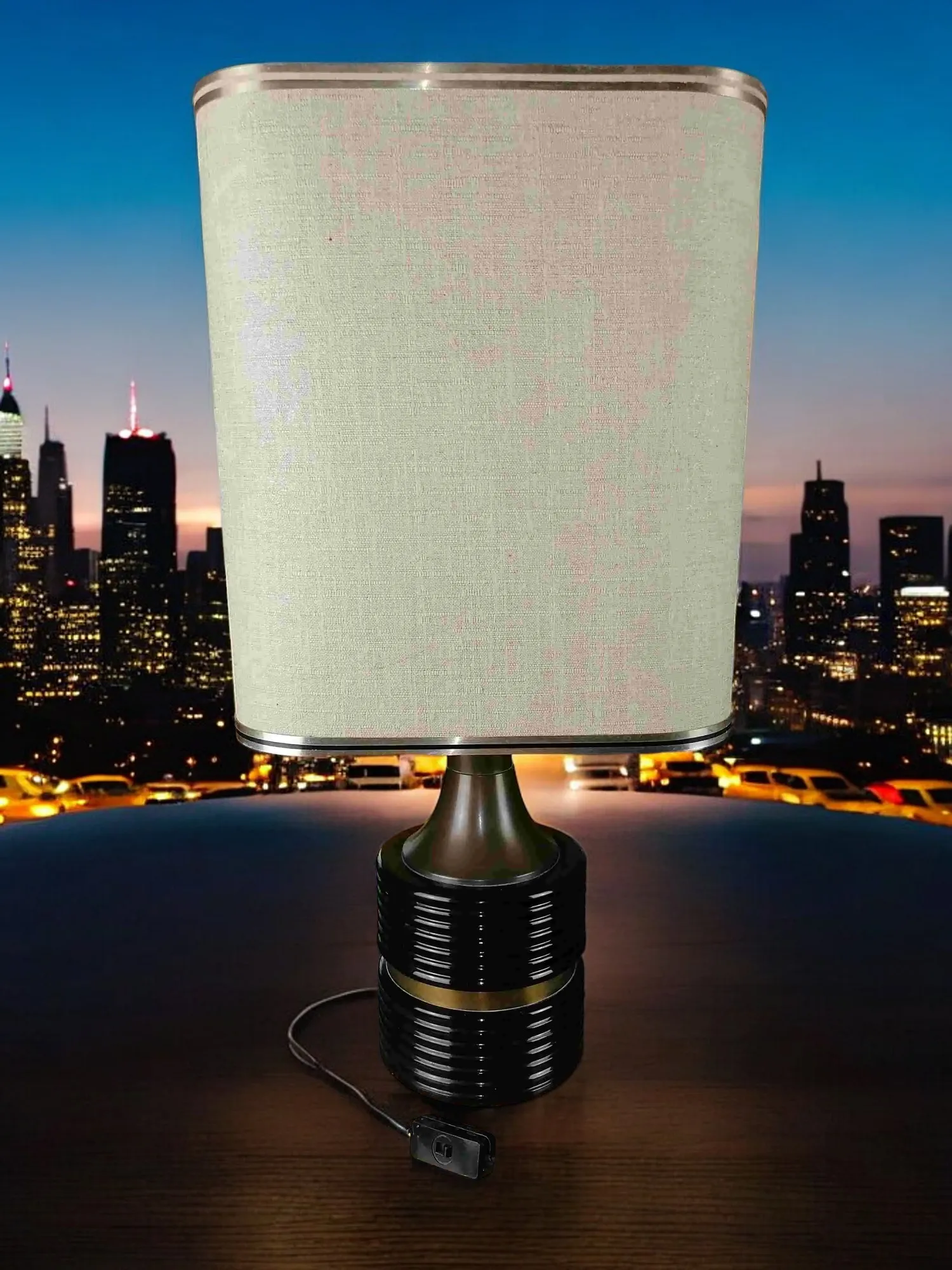 Cette lampe de table est un véritable chef-d'œuvre de design, alliant l'élégance du laiton à la modernité de l'aluminium émaillé. Son abat-jour en papier laminé diffuse une lumière chaude et enveloppante, créant une atmosphère accueillante dans chaque pièce. Les finitions brillantes et les détails soignés font de cette lampe un élément distinctif, parfait pour éclairer un bureau ou un salon. La fusion des matériaux classiques et contemporains en fait un élément décoratif qui ne passe pas inaperçu.