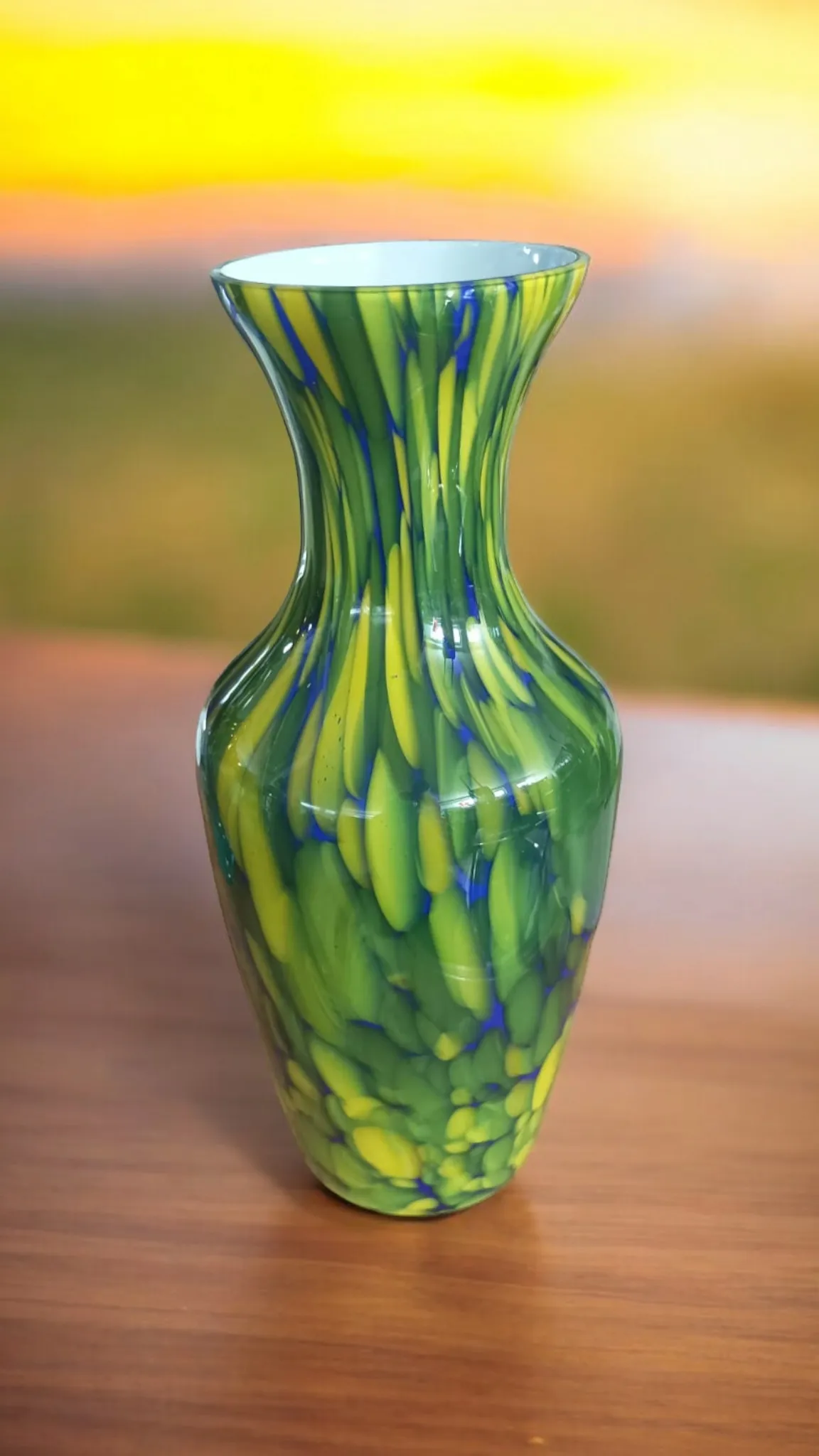 Le Vase de Murano opalin est un exemple extraordinaire de la tradition verrière vénitienne, réputée pour sa qualité et sa beauté intemporelle. Le terme “opalino” fait référence à un type particulier de verre qui présente une finition mate et une luminosité douce, rappelant la délicatesse de l'opale. Ce type de verre a été utilisé pendant des siècles par les maîtres verriers de Murano pour créer des pièces uniques et fascinantes, avec des reflets et des jeux de lumière qui captent l'attention. Caractéristiques principales : Matériau précieux : Le verre opalin de Murano est connu pour sa translucidité et l'effet lumineux qu'il produit lorsque la lumière le traverse. C'est un verre soufflé à la main, ce qui permet un travail fin et détaillé. Couleurs dégradées et douces : Les vases opalins sont souvent caractérisés par des couleurs délicates et des nuances douces, telles que le blanc laiteux, le rose, le bleu ou le bleu clair, offrant un aspect sophistiqué et romantique. Technique artisanale : Chaque vase est réalisé avec des techniques traditionnelles de soufflage et de travail du verre, rendant chaque pièce unique. Le savoir-faire des verriers muranesi se reflète dans les détails précis et les formes élégantes du vase. Pourquoi le choisir : Un Vase de Murano opalin est un élément décoratif idéal pour ceux qui souhaitent ajouter une touche d'élégance discrète et de raffinement à leur maison. Parfait pour les décors classiques, mais aussi pour les environnements modernes où le contraste entre le verre opalin et le design contemporain crée un effet fascinant. Ce vase est également un excellent choix pour ceux qui apprécient l'art du verre et recherchent une pièce unique à collectionner. Le Vase de Murano opalin n'est pas seulement un objet décoratif, mais aussi un témoignage de la tradition artisanale de Murano, une pièce qui raconte l'histoire de siècles de maîtrise verrière. Choisir un Vase opalin de Murano, c'est apporter chez soi une œuvre d'art et de culture qui durera dans le temps, rendant chaque environnement plus lumineux et raffiné.