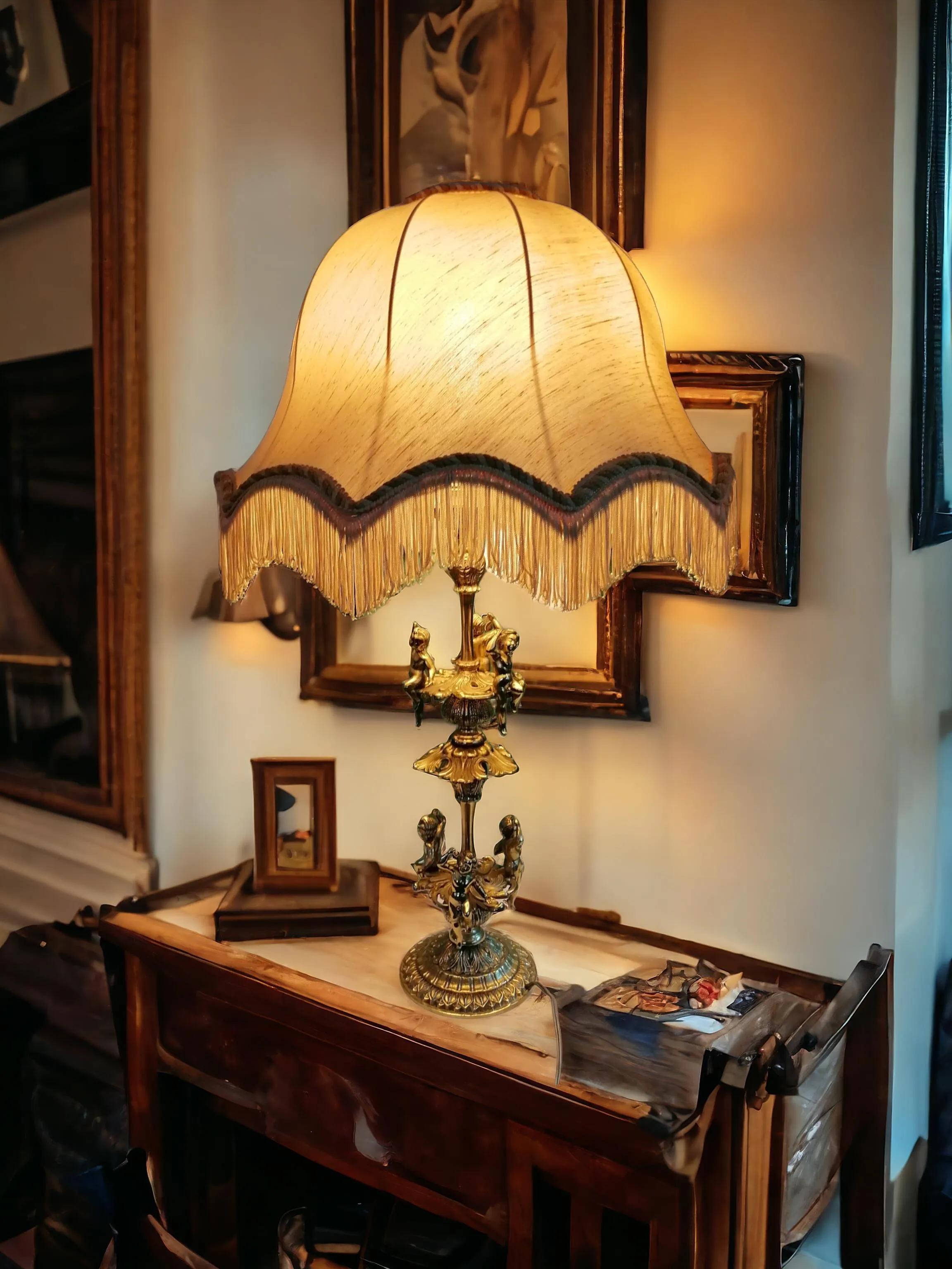 Cette lampe de table est un véritable chef-d'œuvre au style classique et sophistiqué. La base en laiton massif est ornée de détails finement travaillés, parmi lesquels de gracieux putti ajoutent une touche d’élégance romantique et artistique. Parfaite pour les environnements raffinés, cette lampe diffuse une lumière chaude et accueillante, idéale pour sublimer les salons, les bureaux ou les chambres à coucher de style classique. Un élément décoratif qui rappelle le charme intemporel de l'art antique.