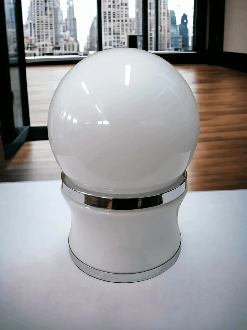 La lampe de table en verre à globe de Goffredo Reggiani est une fascinante expression du design italien des années 60 et 70, renommée pour sa forme simple et son élégance intemporelle. Composée d'un diffuseur en verre en forme de globe, cette lampe offre une lumière douce et diffusée, créant une atmosphère accueillante et raffinée. La base, souvent en métal chromé ou acier, ajoute une touche moderne et industrielle, en parfaite harmonie avec le verre. Idéale pour aménager des espaces contemporains ou des espaces au style rétro, cette lampe est parfaite pour ceux qui apprécient le design vintage et recherchent une pièce iconique alliant esthétique et fonctionnalité.