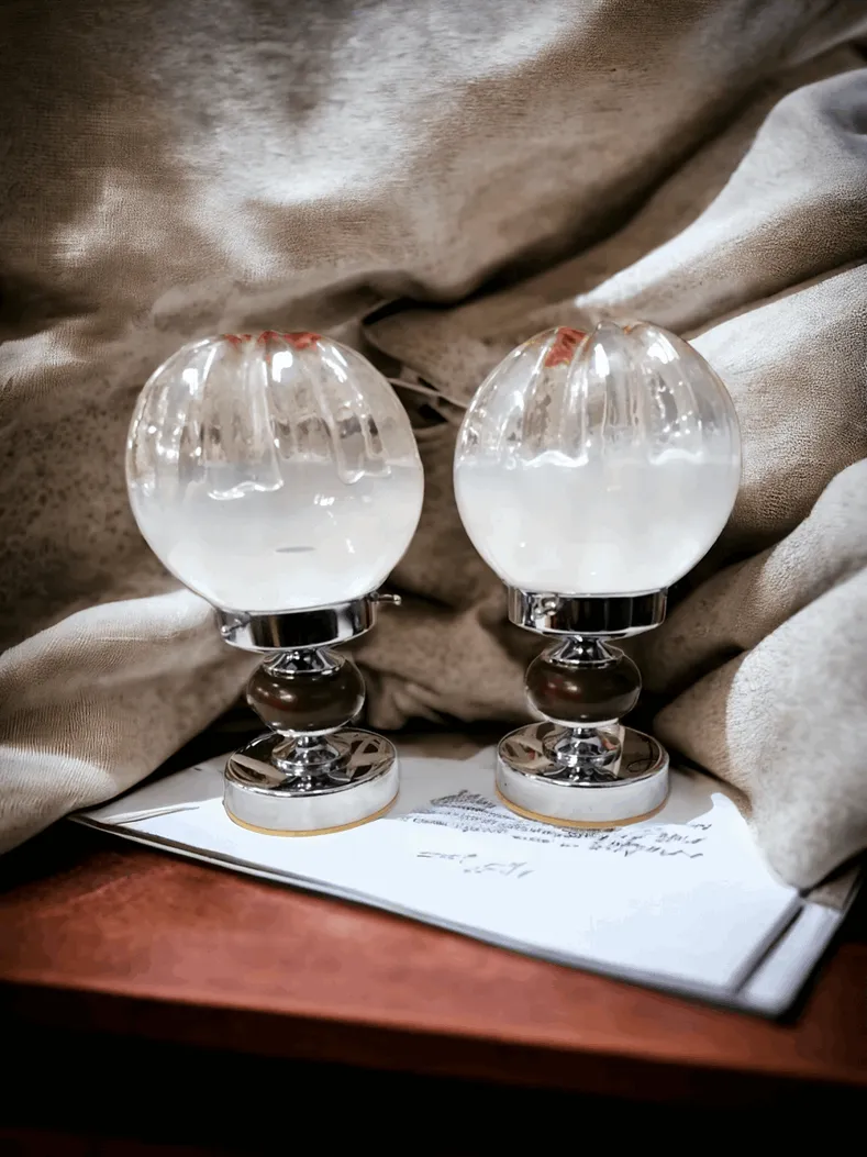 Les lampes de table en verre de Murano Mazzega sont des œuvres d'art qui allient tradition et innovation, grâce au savoir-faire artisanal typique du verre de Murano. Ces lampes, caractérisées par des formes élégantes et des textures uniques, sont souvent réalisées avec des techniques de soufflage créant des effets de lumière et de couleur extraordinaires. Chaque pièce est unique, avec des détails raffinés qui ajoutent une touche de luxe à n'importe quel environnement. Idéales pour ceux qui désirent un élément décoratif distinctif, les lampes de table Mazzega sont parfaites pour ajouter de l'élégance et du charme intemporel à des espaces classiques et contemporains, transformant la lumière en une véritable expérience visuelle.