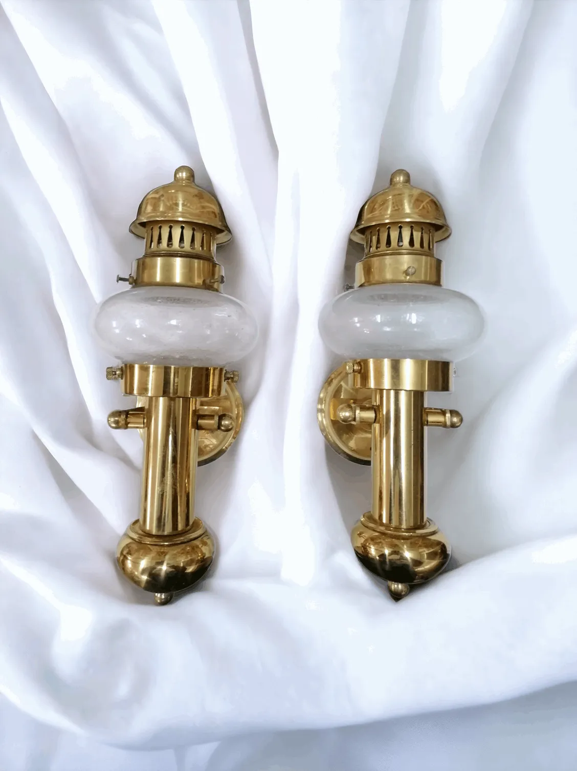 Les appliques murales en laiton et verre soufflé allient élégance classique et artisanat de haute qualité. La structure en laiton apporte une touche de chaleur et de raffinement, tandis que le verre soufflé à la main crée une lumière douce et diffuse, idéale pour créer une atmosphère accueillante dans n'importe quel environnement. Avec leurs formes sinueuses et leurs détails sophistiqués, ces appliques s'adaptent parfaitement à des intérieurs modernes ou vintage, ajoutant un élément décoratif intemporel. Idéales pour les couloirs, salons ou chambres à coucher, elles sont parfaites pour ceux qui désirent un éclairage élégant et impactant.