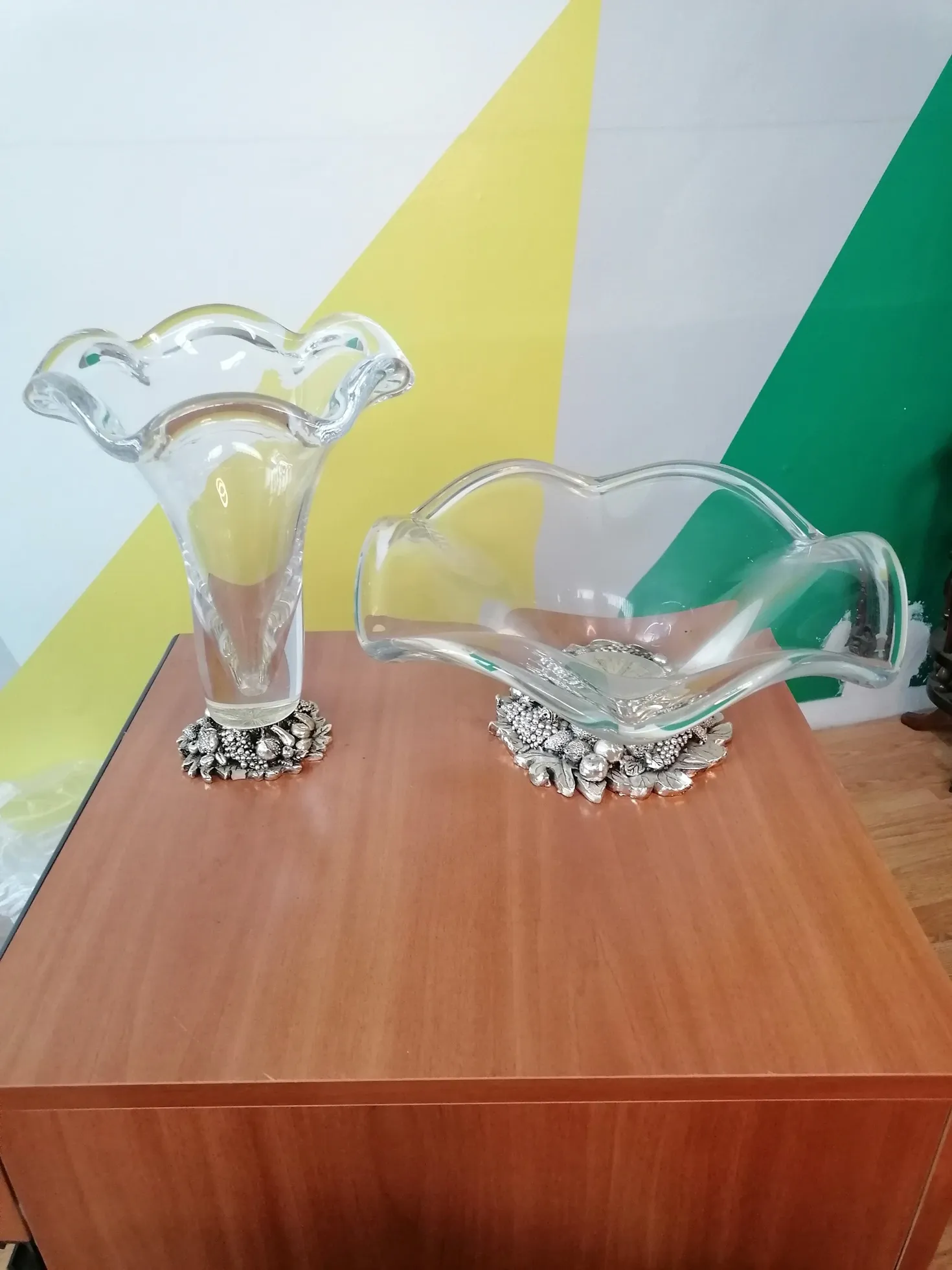 Le Vase et porte-fruits de Murano avec base en résine plaquée argent est un exemple raffiné d'art verrier qui allie la tradition du verre de Murano à la modernité des matériaux, créant ainsi un objet décoratif élégant et distinctif. La combinaison du verre soufflé à la main, avec une finition mate et brillante, et la base en résine plaquée argent, confère au vase et au porte-fruits une beauté unique qui met en valeur la lumière et l'environnement. Caractéristiques principales : Matériau de haute qualité : La base en résine plaquée argent donne au vase une sensation de luxe et de robustesse, tandis que le verre de Murano, réputé pour sa transparence et ses couleurs éclatantes, complète le design avec une touche artisanale inimitable. Design élégant : La combinaison de verre et d'argent crée une fusion harmonieuse entre tradition et modernité, avec une structure qui exprime raffinement et originalité. Le vase et le porte-fruits peuvent comporter des décorations faites à la main, incluant des détails en relief ou des nuances de couleurs uniques. Fonctionnalité et décoration : En plus d'être un objet décoratif impressionnant, le porte-fruits est idéal pour ajouter un élément pratique à la table, offrant de l'espace pour des fruits, des bonbons ou servant même de contenant décoratif élégant dans n'importe quel environnement. Pourquoi le choisir : Le Vase et porte-fruits de Murano avec base en résine plaquée argent est parfait pour ceux qui recherchent un complément de décoration qui allie élégance, luxe et fonctionnalité. La qualité du verre et du placage en fait une pièce très recherchée par les collectionneurs, mais aussi un excellent choix pour ceux qui souhaitent ajouter une touche de classe à leur salon, salle à manger ou comme centre de table. Un objet qui se distingue par sa beauté et sa fonctionnalité, idéal pour des occasions spéciales ou comme cadeau raffiné.