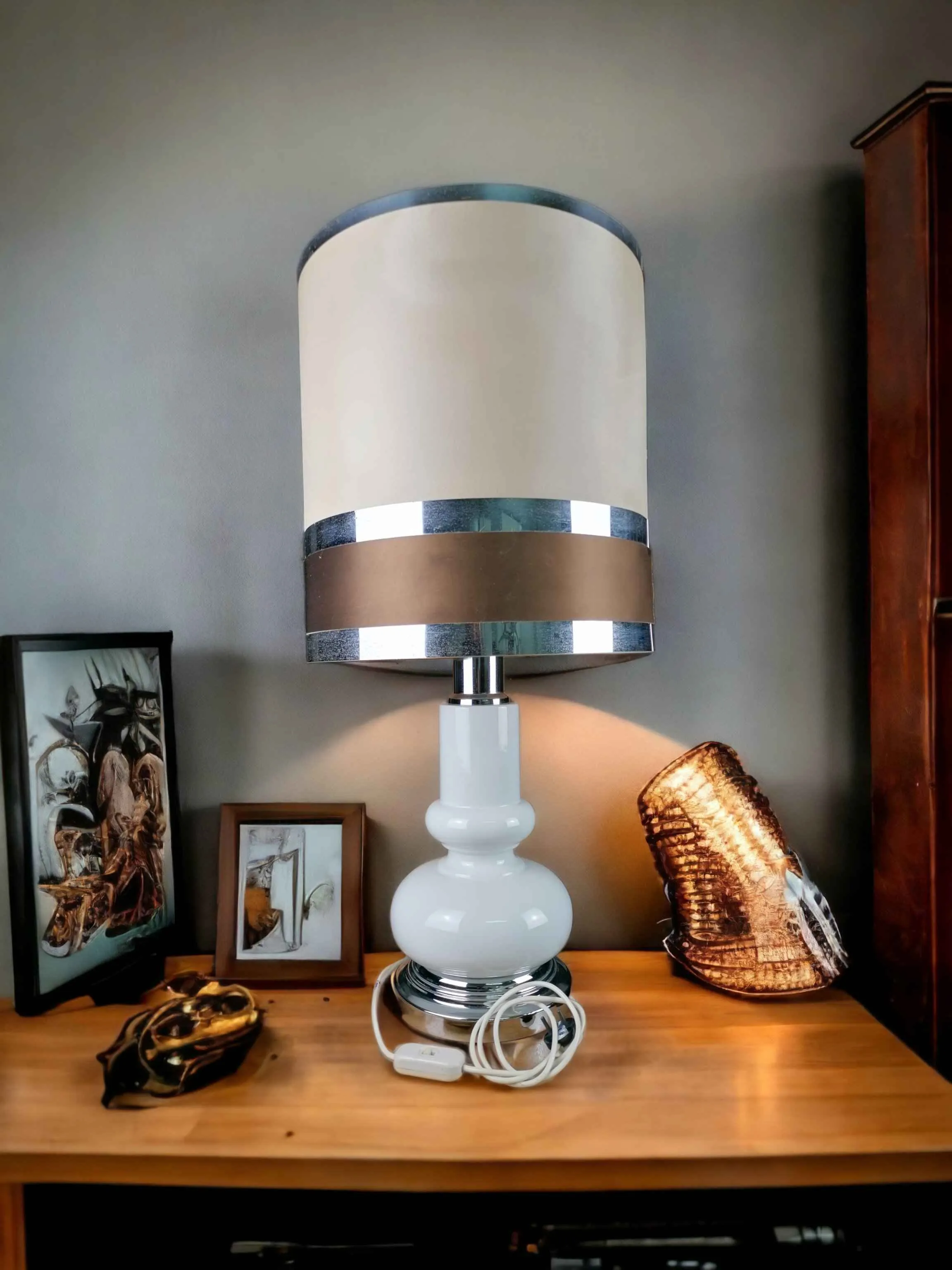 Lampe de table Space Age des années 70 au style italien moderne, caractérisée par une esthétique futuriste et raffinée. Cette lampe unique, réalisée avec des matériaux de haute qualité tels que la céramique, le métal et le parchemin, associe l'élégance des détails argentés à la pureté du blanc et à la chaleur du marron. En excellent état de conservation, cette icône vintage est parfaite pour ajouter une touche de design rétro-futuriste à n'importe quel environnement, offrant une lumière suggestive et un style inconfondable.