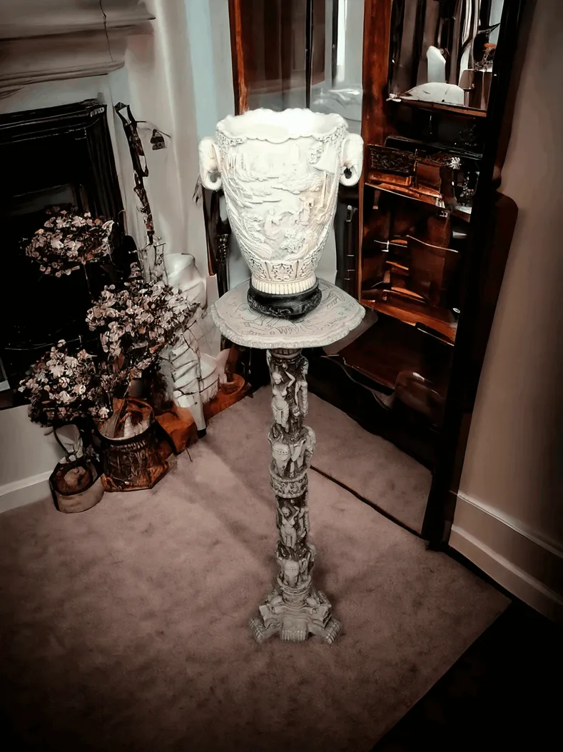 Die Orientalische Säule mit Vase ist ein einzigartiges und eindrucksvolles Möbelstück, das von der orientalischen Ästhetik inspiriert ist und perfekt dazu geeignet ist, jedem Raum einen exotischen und eleganten Touch zu verleihen. Diese Säule besteht aus hochwertigen Materialien wie geschnitztem Holz, dekorierter Keramik oder bearbeitetem Stein und zeigt filigrane Details und Muster, die sich an der künstlerischen Tradition des Fernen Ostens orientieren. Hauptmerkmale: Material und Design: Der Körper der Säule ist oft mit Intarsien oder handgemalten Dekorationen versehen, die Symbole und orientalische Motive wie Drachen, Lotusblumen und traditionelle geometrische Formen darstellen. Passende Vase: Die Vase, die sich an der Spitze befindet, ist dafür gedacht, Pflanzen oder Blumen zu beherbergen oder als Einzelstück ausgestellt zu werden und trägt dazu bei, einen eleganten und harmonischen Mittelpunkt zu schaffen. Nutzung: Diese Säule eignet sich ideal für Innenräume wie Wohnzimmer, Eingänge und Büros, wo sie Tiefe und einen anspruchsvollen Stil verleiht.