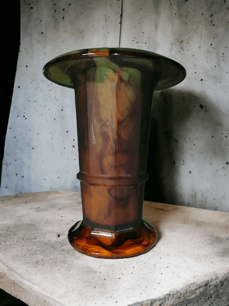 Le vase Art Déco de George Davidson, produit par la célèbre société britannique, est un magnifique exemple de design Art Déco, connu pour son élégance sophistiquée et l'utilisation innovante des matériaux. George Davidson, une entreprise qui a marqué l'histoire de la verrerie britannique, est célèbre pour sa capacité à allier tradition et modernité, créant des objets d'une grande valeur esthétique et fonctionnelle. Caractéristiques principales : Design Art Déco : Ce vase représente l'apogée du style Art Déco, avec des lignes géométriques épurées, des motifs stylisés et une palette de couleurs jouant sur le contraste entre lumière et ombre. Les objets Art Déco sont reconnus pour leur symétrie, l'utilisation de matériaux précieux et le mélange de formes modernes et raffinées. Matériaux de haute qualité : Le vase est fabriqué en cristal ou en verre de haute qualité, avec des détails finement travaillés qui témoignent du savoir-faire des maîtres verriers de George Davidson. Décorations : Le vase est décoré de motifs caractéristiques de l'époque Art Déco, pouvant inclure des gravures, des sculptures ou des peintures qui accentuent sa beauté géométrique et stylisée. Pourquoi le choisir : Ce vase Art Déco de George Davidson est un objet rare et fascinant, parfait pour ceux qui recherchent un article alliant fonctionnalité et art. Son esthétique raffinée le rend idéal pour décorer des espaces modernes ou classiques, comme des salons élégants, des bureaux de haut niveau ou des galeries d'art. C'est aussi un objet de collection pour les passionnés de design vintage, qui apprécient l'artisanat et l'histoire derrière chaque pièce.