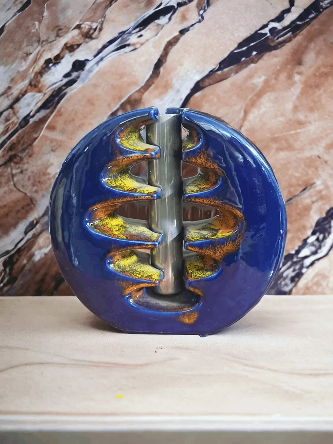 Le Vase Space Age Bertoncello Céramique d'art Très rare est un exemple extraordinaire de design céramique innovant, typique de la période Space Age, couvrant la fin des années 50 et les années 60, lorsque les influences futuristes et l'utilisation de formes géométriques et de couleurs audacieuses dominaient dans le monde de l'art et du design. Ce vase, réalisé par la prestigieuse Bertoncello Céramique d'art, est une pièce de collection qui reflète pleinement l'esthétique spatiale de l'époque, reconnu pour sa rareté et sa valeur historique. Caractéristiques principales : Design futuriste : Le vase se distingue par ses formes arrondies et ses lignes fluides qui rappellent les silhouettes aérodynamiques, caractéristiques typiques de la période Space Age. Le design est une fusion entre l'art et la science, avec des éléments qui évoquent l'exploration spatiale et l'innovation technologique de l'époque. Matériau de haute qualité : Réalisé en céramique de haute qualité, le vase a été décoré avec des émaux et des finitions qui reflètent la lumière, accentuant la brillance et l'unicité de la pièce. La technique de fabrication et la qualité artisanale sont typiques de Bertoncello, une marque renommée pour son excellence dans le domaine. Rareté et valeur : En tant que pièce très rare, le vase est très recherché par les collectionneurs et les amateurs d'art du XXe siècle, notamment ceux intéressés par la céramique artistique italienne et les objets de design vintage. Sa production limitée en augmente d'autant plus l'attrait et l'exclusivité. Pourquoi le choisir : Le Vase Space Age Bertoncello Céramique d'art est idéal pour ceux qui recherchent une pièce d'art exclusive et recherchée. Parfait pour les collectionneurs, les amateurs de design et les passionnés d'objets vintage, ce vase représente une occasion unique de posséder un élément qui incarne l'esprit d'une époque pionnière, tant dans le design que dans l'exploration de l'espace. C'est un ajout extraordinaire à toute collection, mais aussi un complément décoratif distinctif pour des maisons modernes, élégantes et contemporaines.